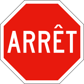 Red octagonal stop sign with white border, featuring the French word "ARRÊT" in bold white letters telling drivers to stop.
