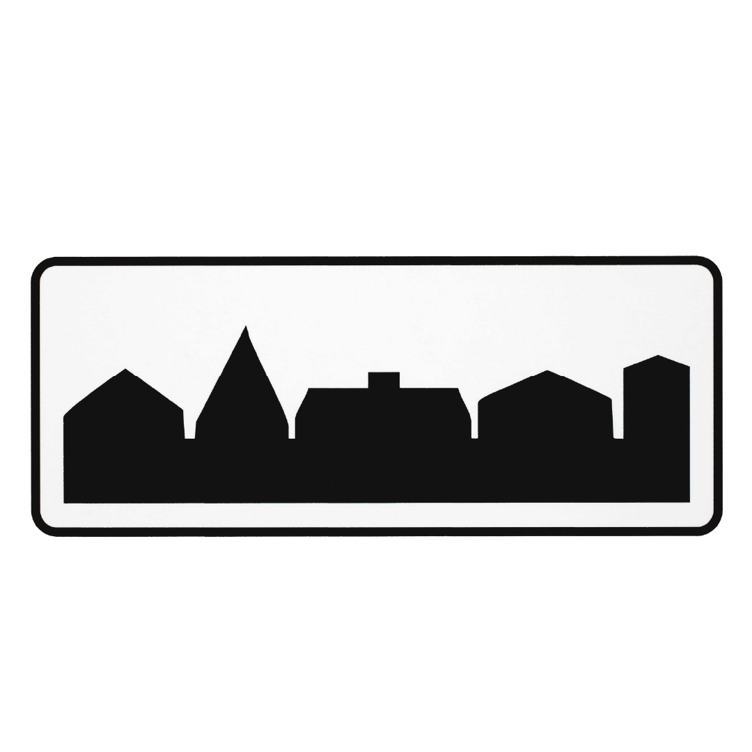 Black and white road sign depicting a city's skyline silhouette.