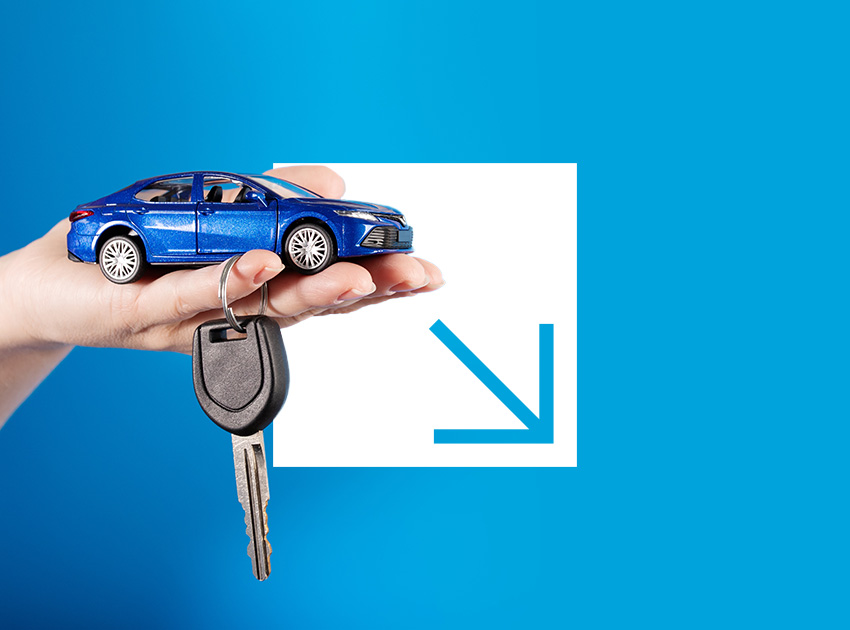 Hand holding a small blue toy car and a car key against a blue background.