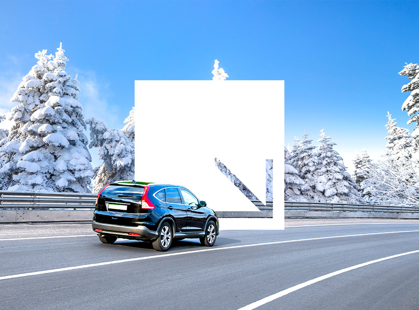 Car driving on an icy winter road, illustrating why car hire excess insurance matters in harsh conditions.