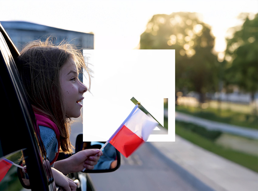 Child holding a Polish flag out of a car window while travelling, highlighting the need for car hire excess insurance when driving in Poland.