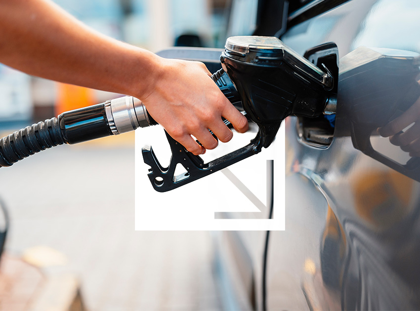 Hand holding a fuel pump nozzle while refuelling a car, relevant for travellers using car hire excess insurance on long journeys.